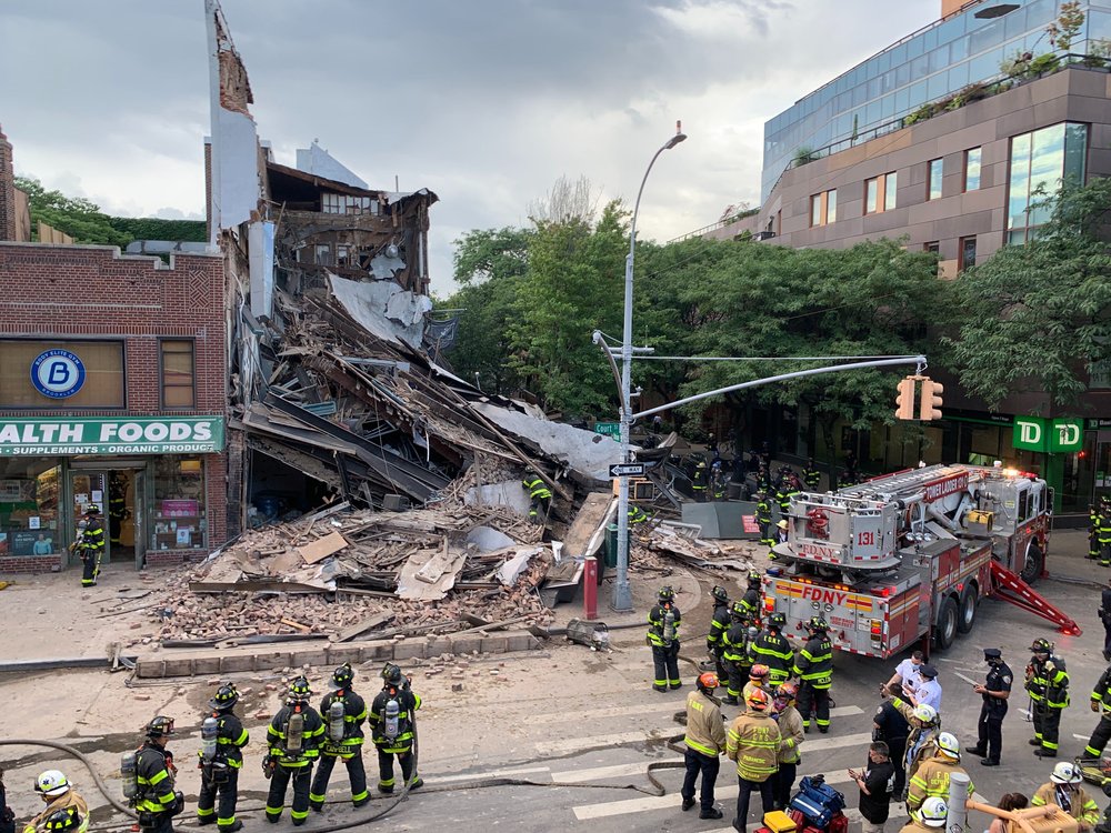 The debris from the collapse building, with Firefighters surrounding it