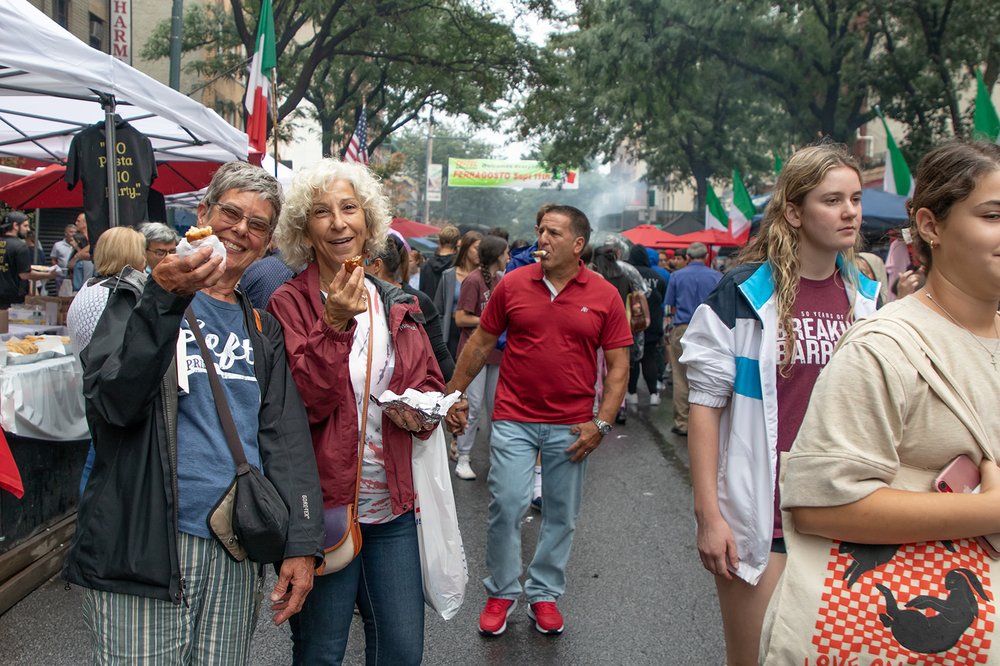 Two women hold up their munchies at a past Ferragosto festival in the Bronx.