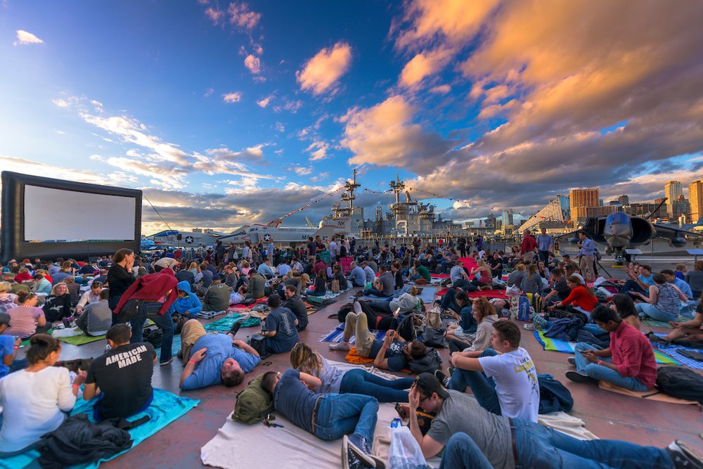 A group of people watch a movie outside.