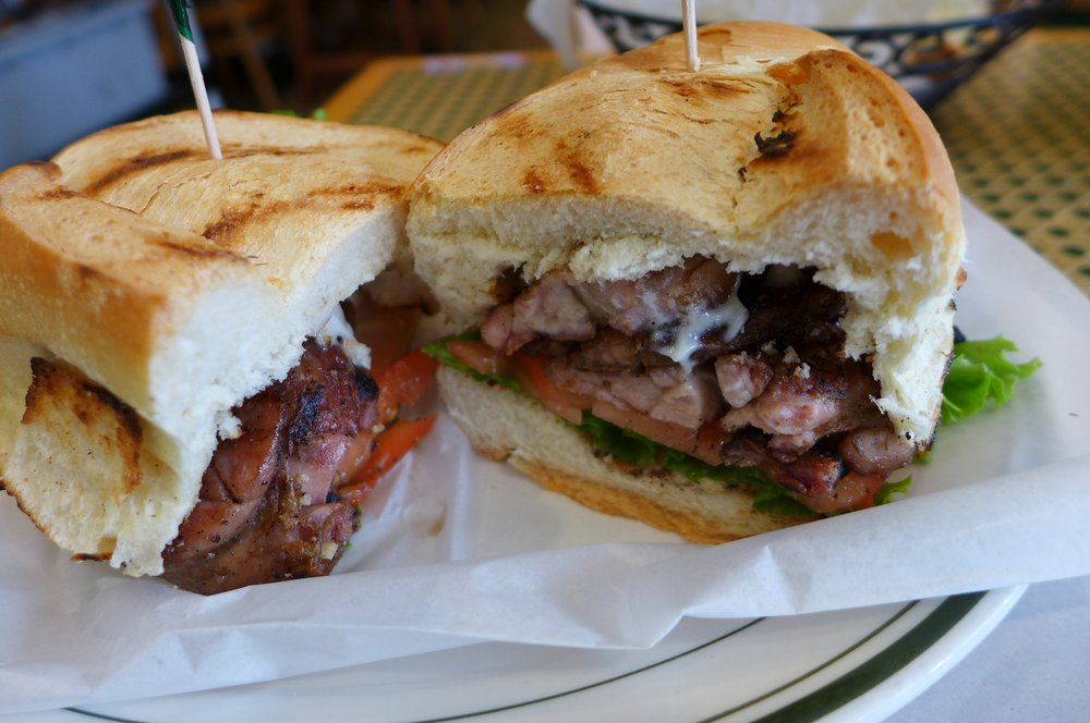 A sandwich with meat, cut in two halves.