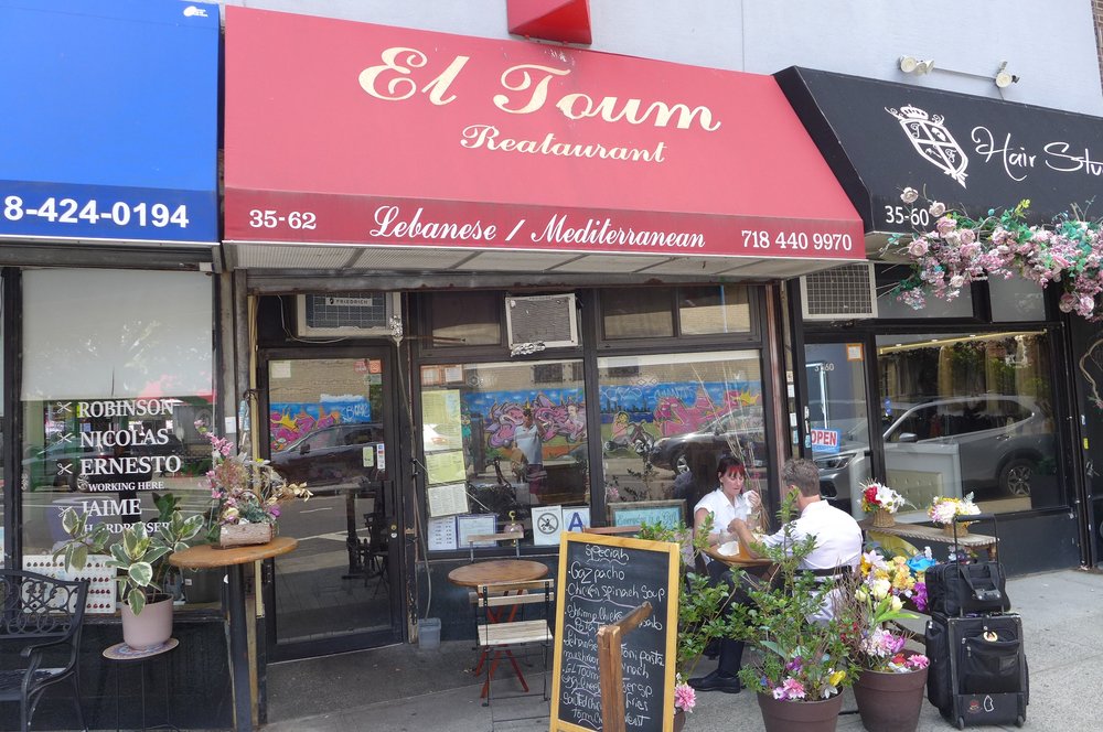 The exterior of a store with a red awning.