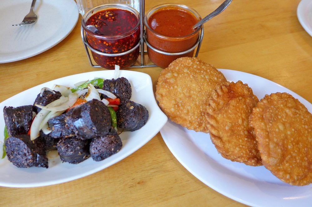 Fried patties and blood sausages on white plates.