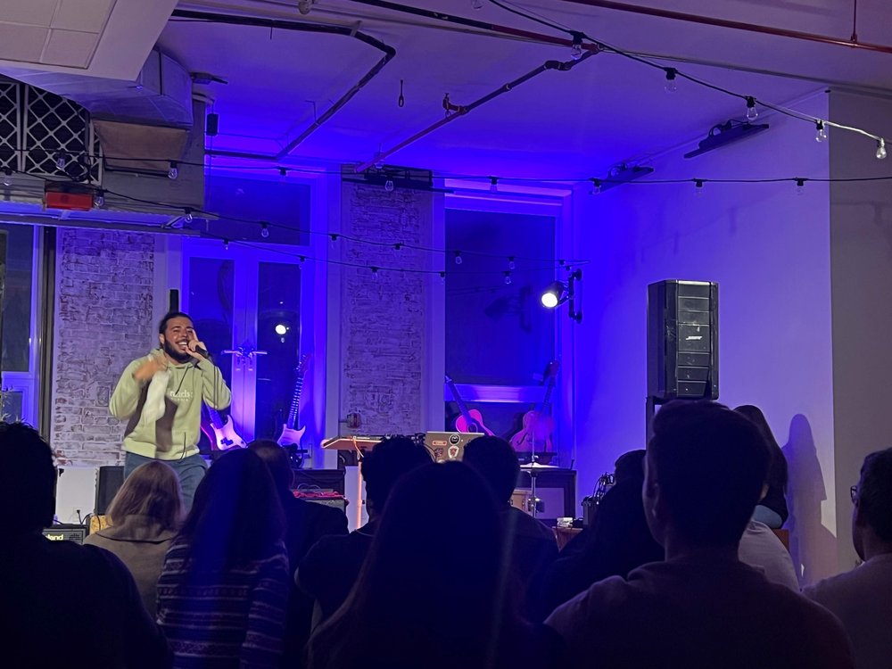 An artist performing inside a workspace with dim blue lights.