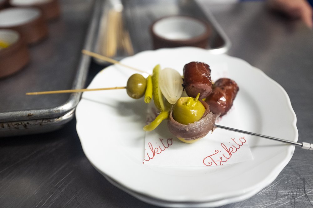 Olives and slightly charred hot dogs on two skewers.