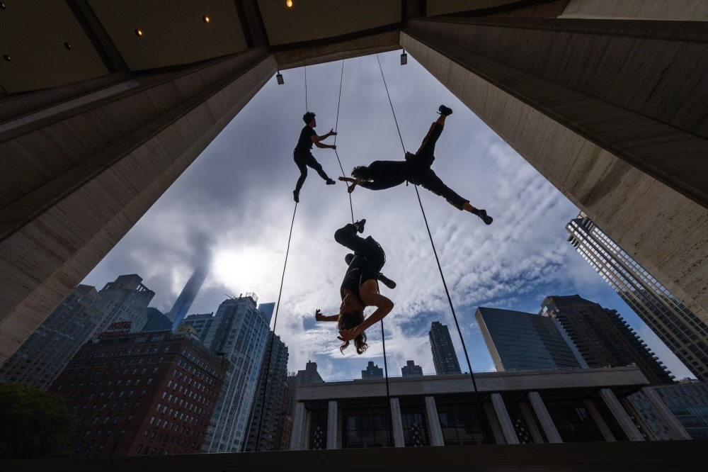 Acrobats rappel down a building