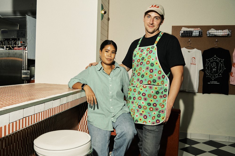 Sutathip Aiemsaard and Trevor Lombaer stand in their Thai-American cafe, Little Grenjai, in Bed-Stuy. The couple met on Tinder in Bangkok in 2016, where Aiemsaard was working as an interior and graphic designer and Lombaer was visiting in hopes of learning about Thai cuisine.