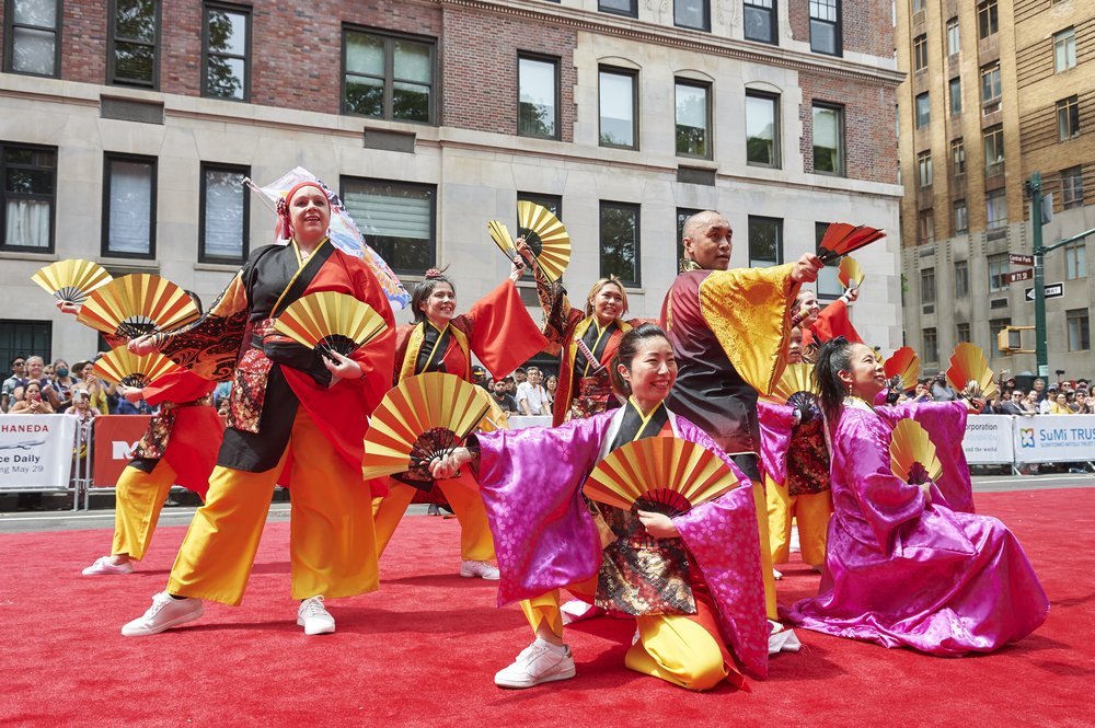 Dancers in colorful costumes perform during a parade.