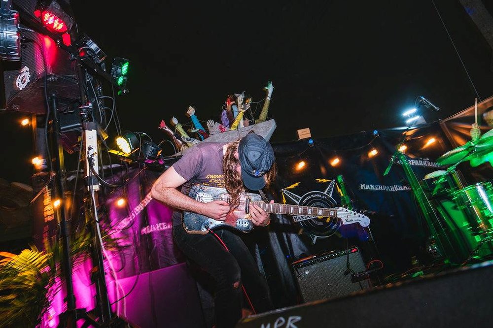 A group of people indoors at a music festival.
