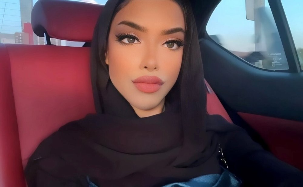 A woman leaning against a car seat.