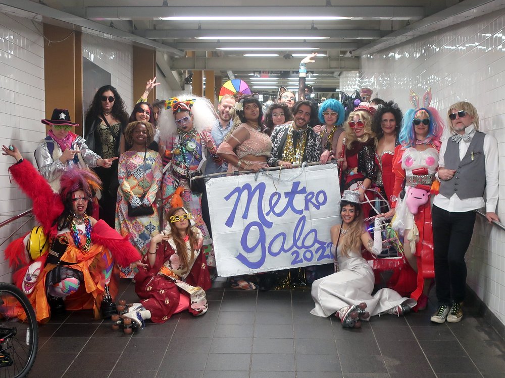 A group of people hold up a sign that says "Metro Gala."