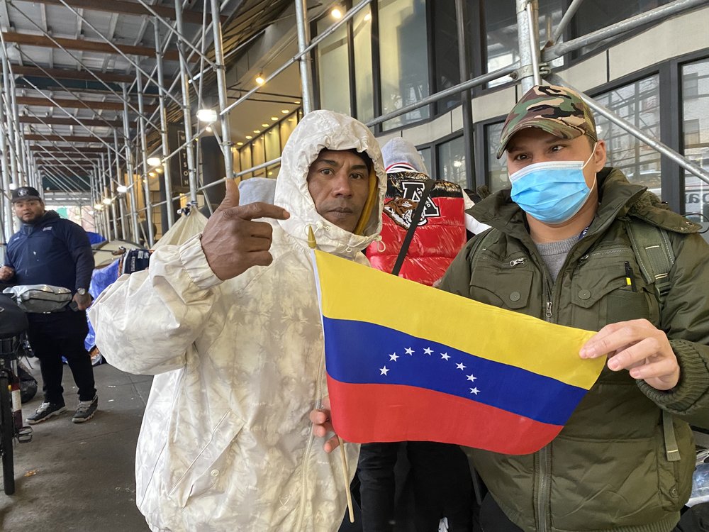 Two men hold a Venezuelan flag.