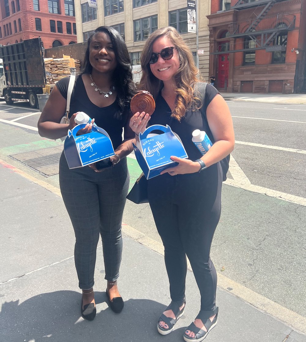 Two people holding treats from Lafayette bakery.