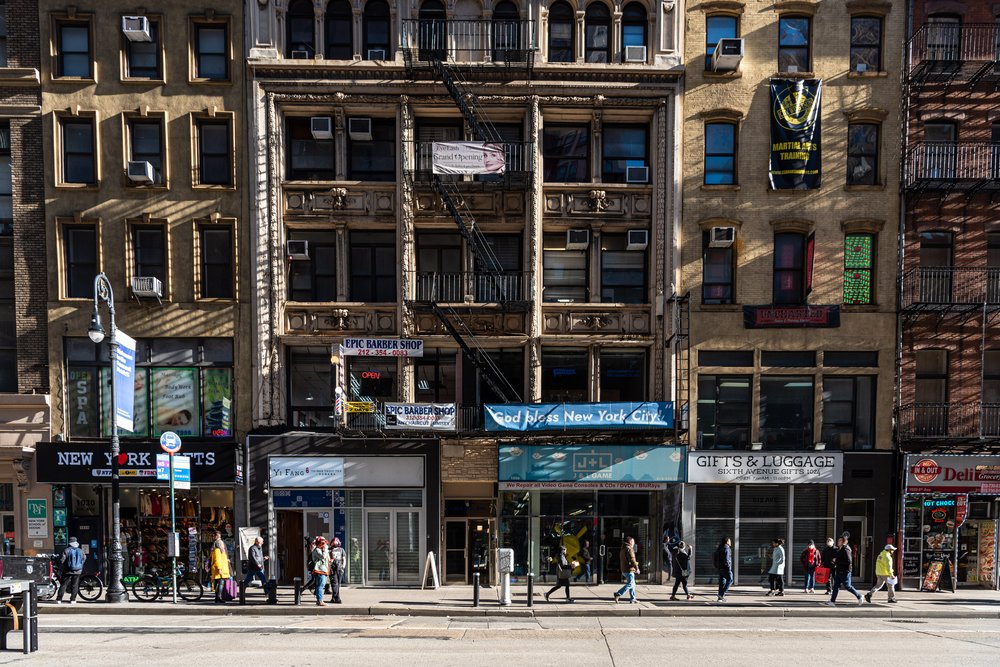 A series of buildings in new york city with people walking by on the sidewalk.