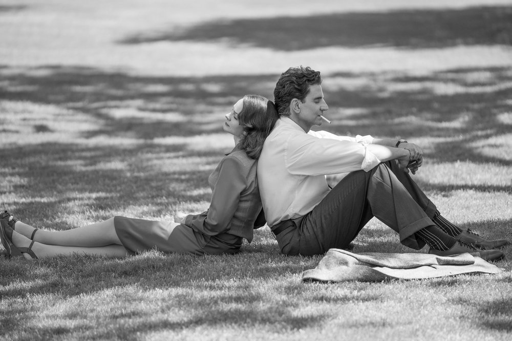 A picture of a two people sitting back to back.