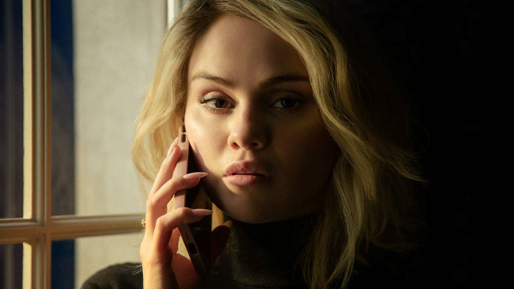 A woman listens on a phone call.