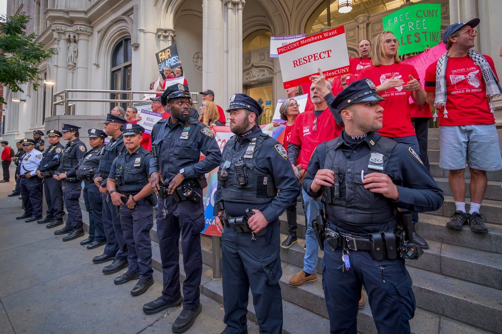 A stock photo of NYPD officers standing in front of protesters.