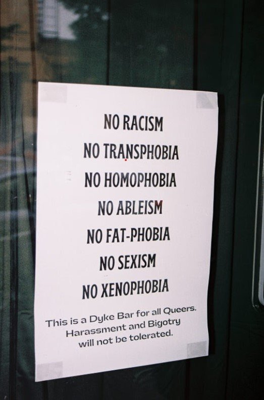 A sign at the bar says "no racism."