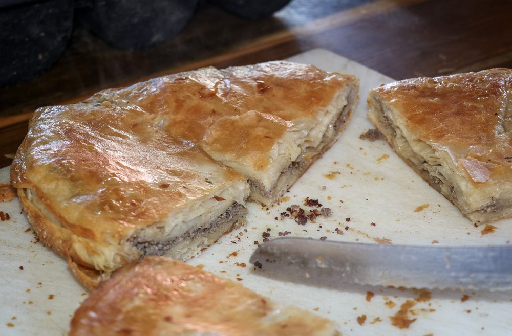 A savory pie filled with meat is cut in half.