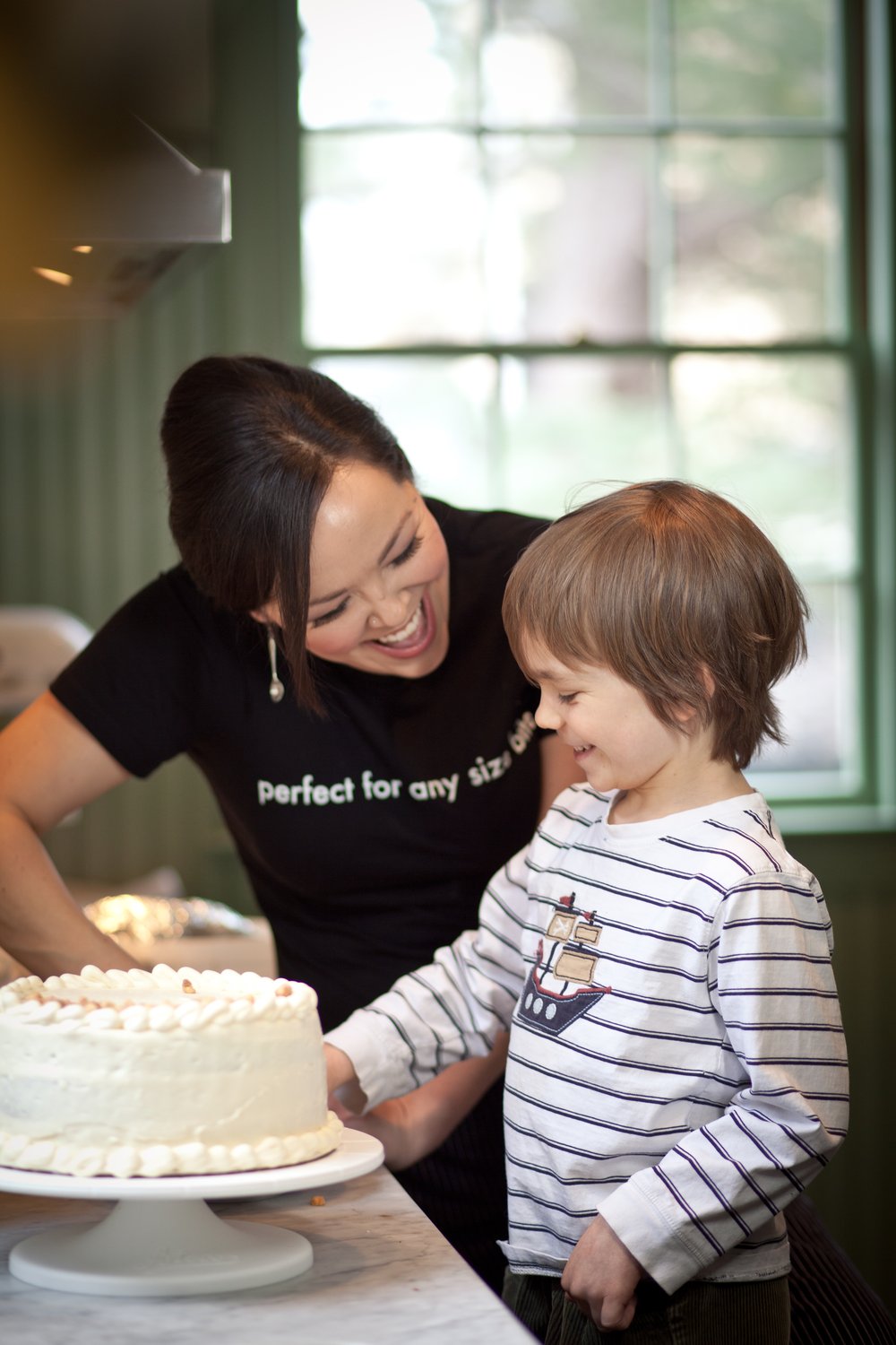 A woman leans down to talk to a small child.