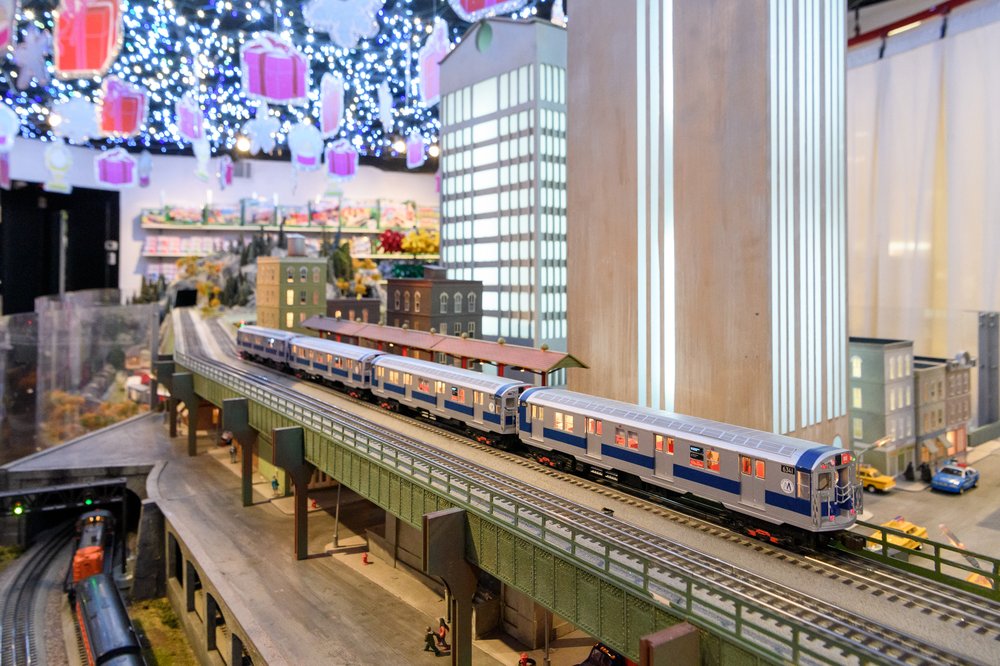 A toy train cruises on a track