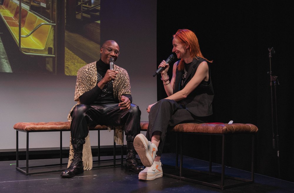 Two people talk onstage.