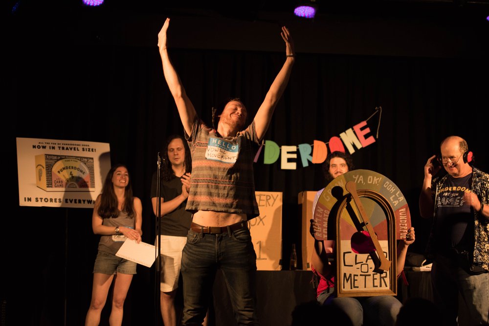 A man stands on stage with his arms outstretched