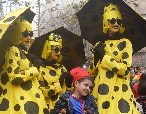 A group of people in costumes hold umbrellas.
