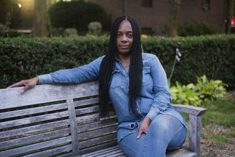 A person sits on a bench with their legs crossed.
