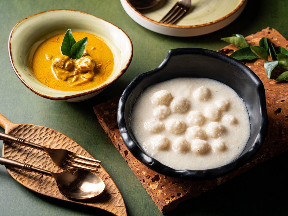Dumplings in a bowl filled with a soup-like liquid placed on a table.