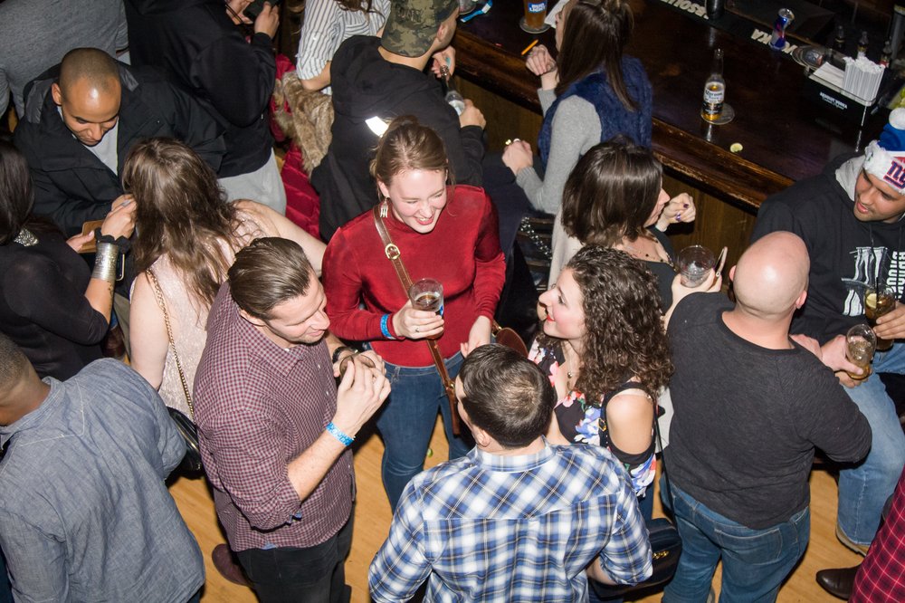 A group of people mingle at a bar.