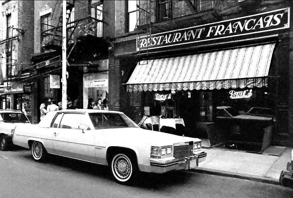 A car parked in front of a restaurant with a sign that says "restaurant francais"
