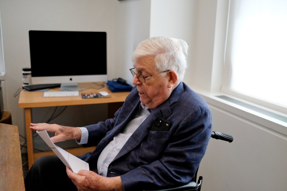 A man in a suit reviews paperwork.