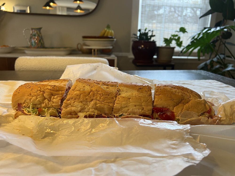 An enormous sandwich cut into four pieces.