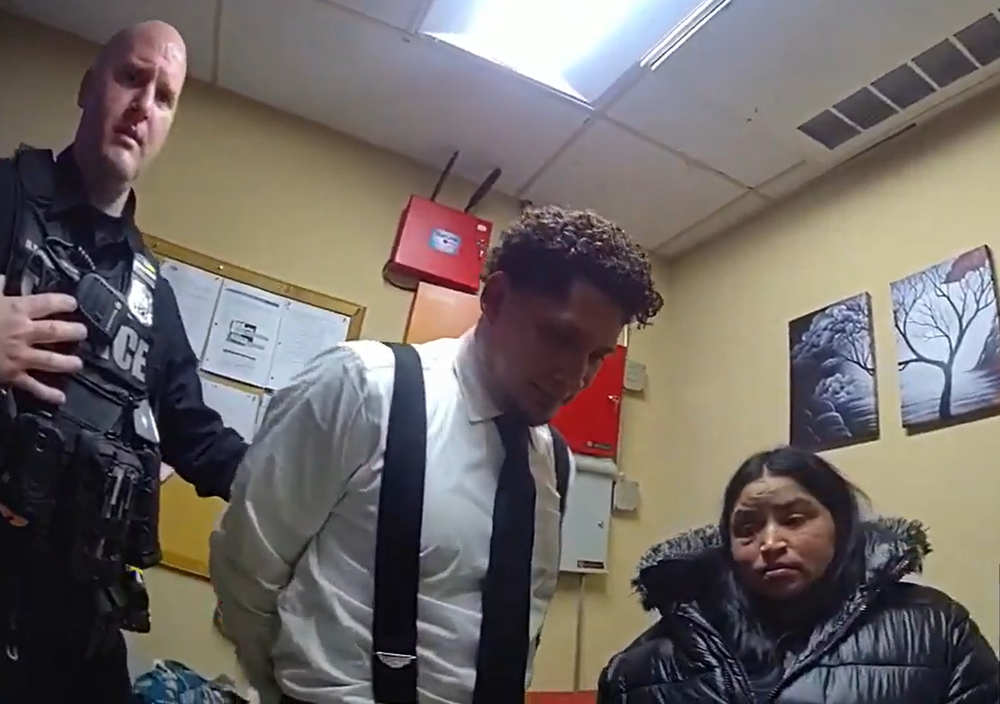 A police officer with a man in handcuffs, standing next to a woman.