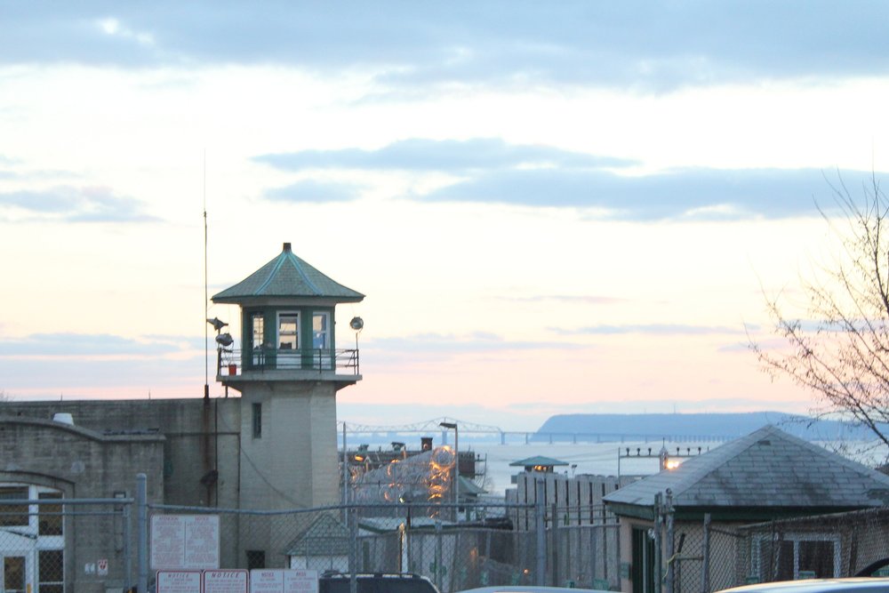 A prison guard tower with a bridge in the background