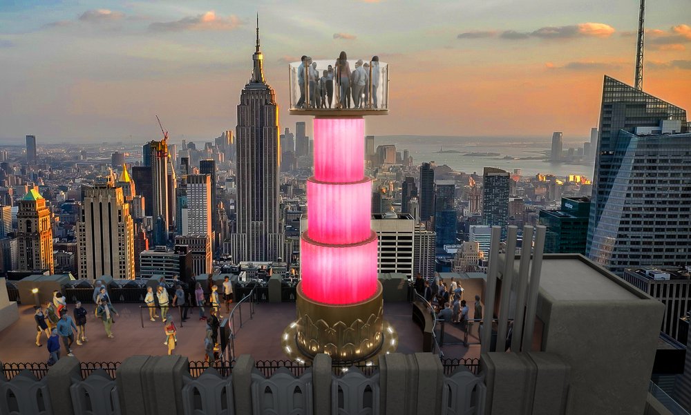 A pink ride glows atop a skyscraper.
