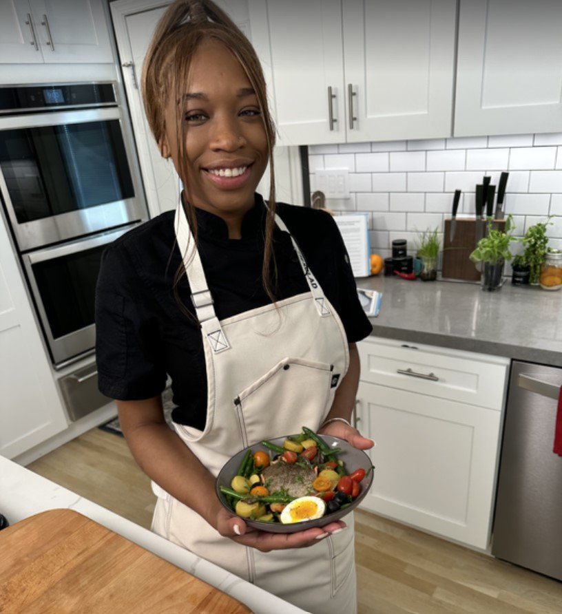 A chef holds a bowl in her hands