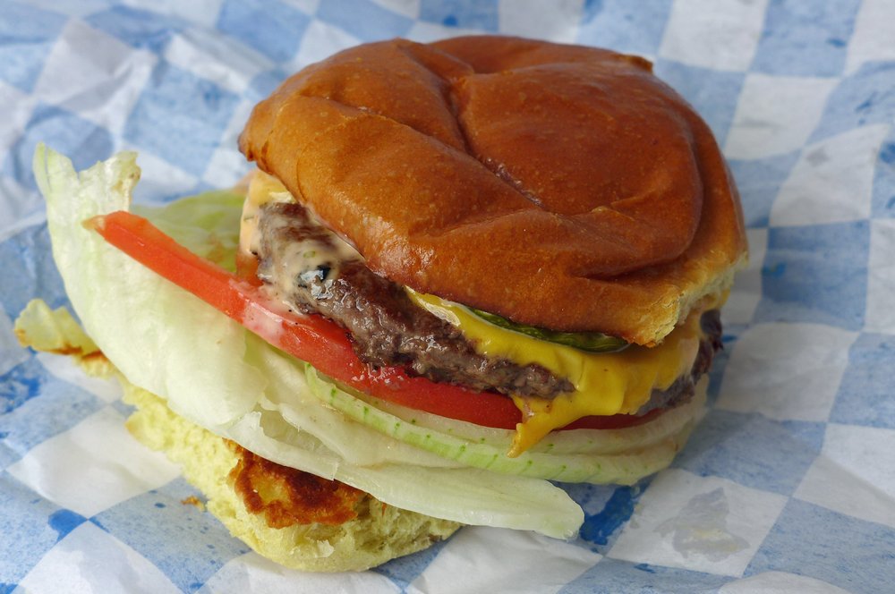 A burger on a blue and white tablecloth.
