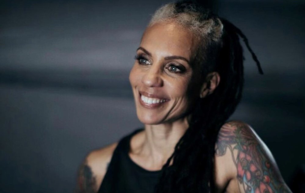 A woman wearing a black tank top smiles.