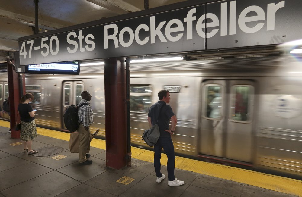 Riders at the 47th-50th Sts Rockefeller subway station in Manhattan as they await an incoming subway.