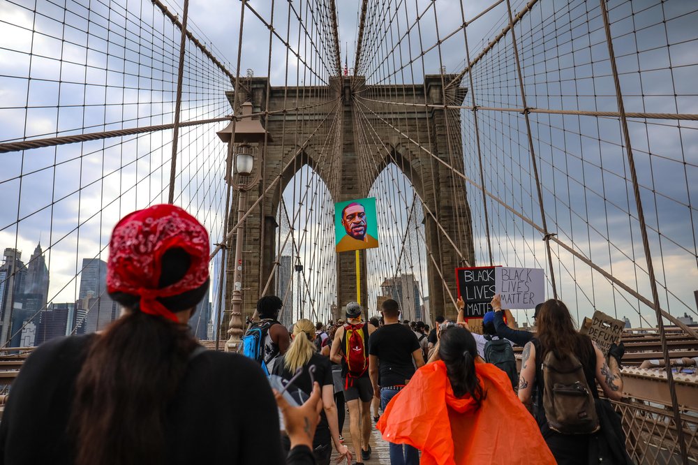 A protest on the Brooklyn Bridge on June 6th with marchers and a George Floyd poster