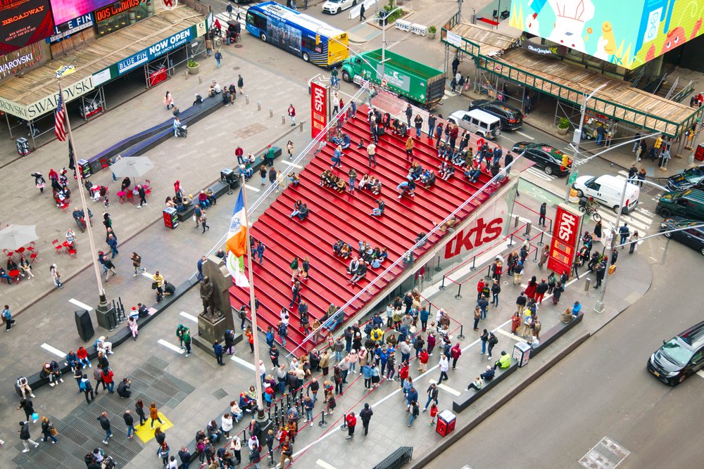 An overhead view of a large flight of bright red steps on a city plaza