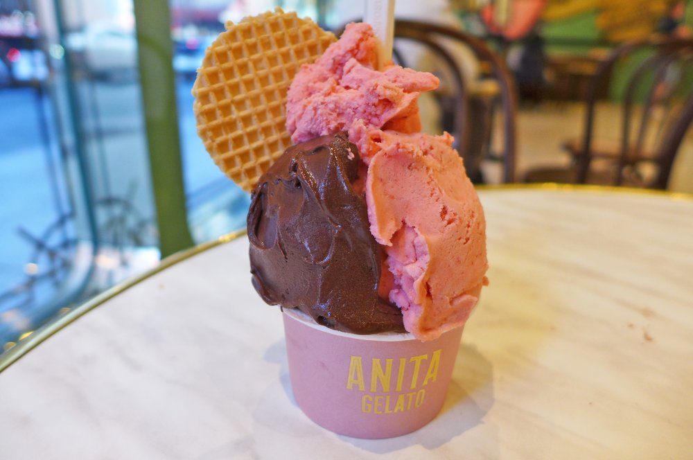 A small cup of double chocolate and strawberry gelato with a wafer cookie placed in the middle.