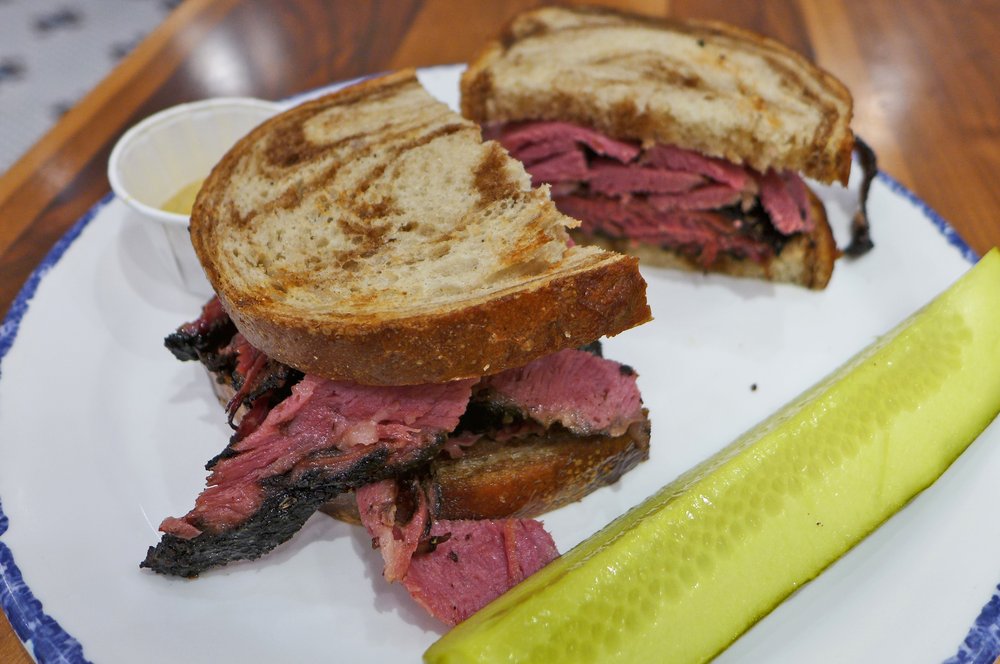 A sandwich with sliced pastrami.