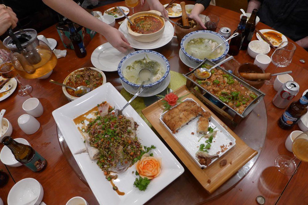Plates of Chinese food on a table shot from above.