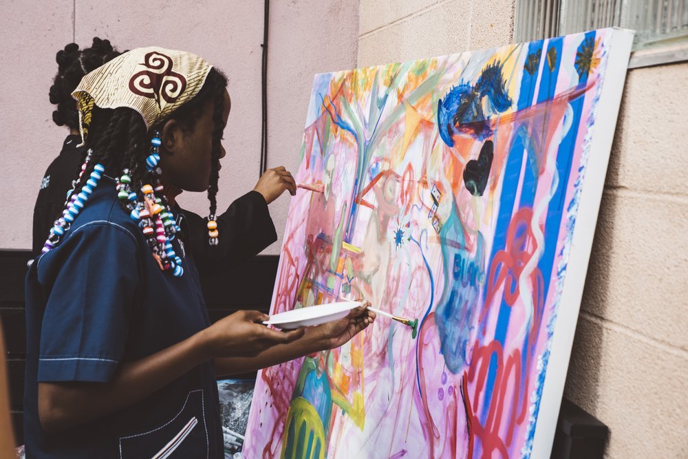 A person paints a colorful canvas.