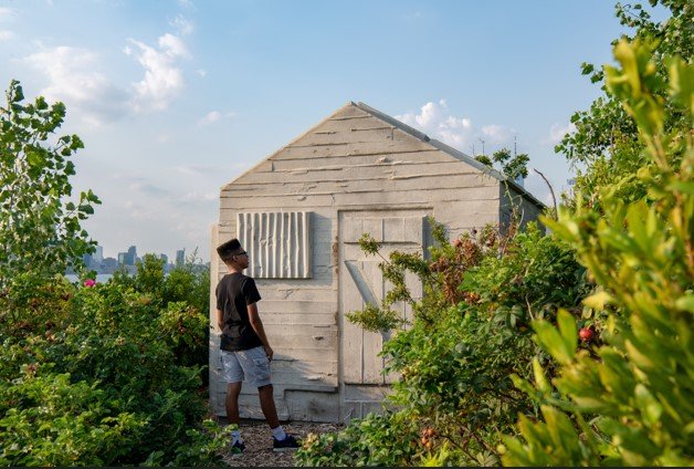 A young person looks at a cabin on Governors Island