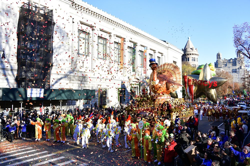A float featuring a turkey, with confetti in the air.