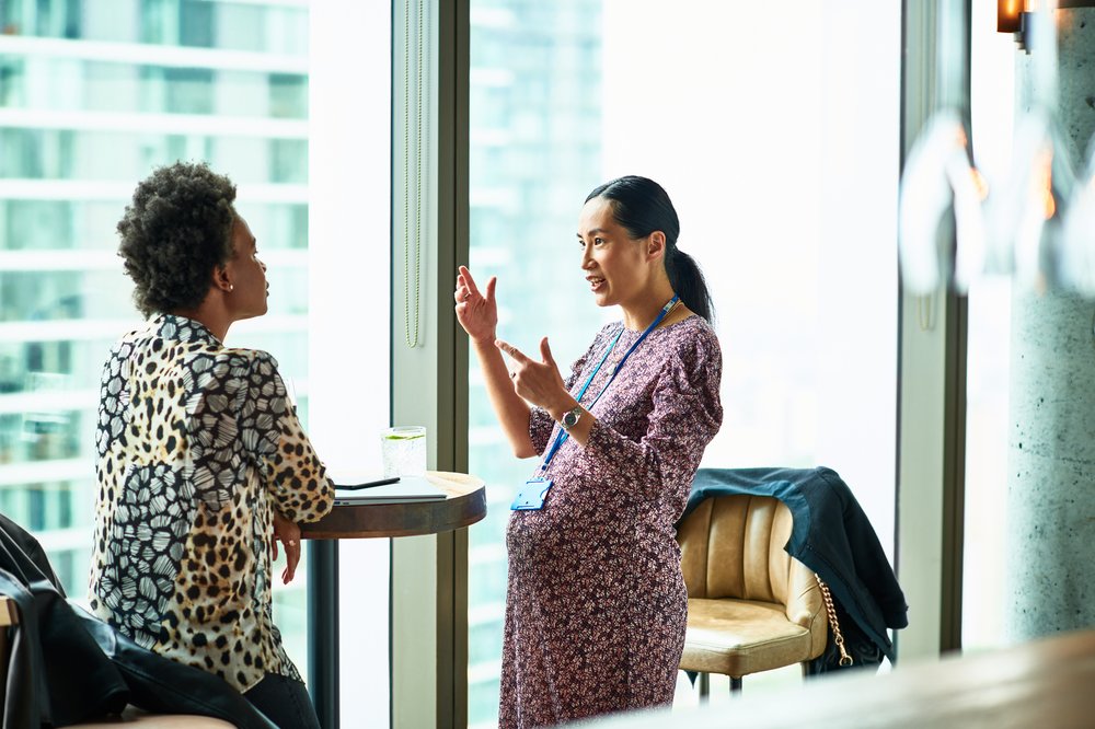 Two women in an office having a conversation.