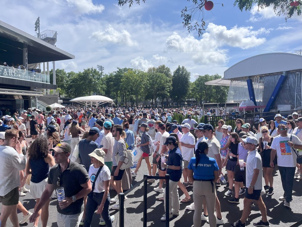 A large crowd walks on the grounds of the 2025 US Open tennis championships in Queens.